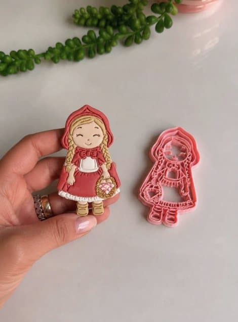 Cortador da Chapeuzinho Vermelho e a boneca de pasta americana na mão